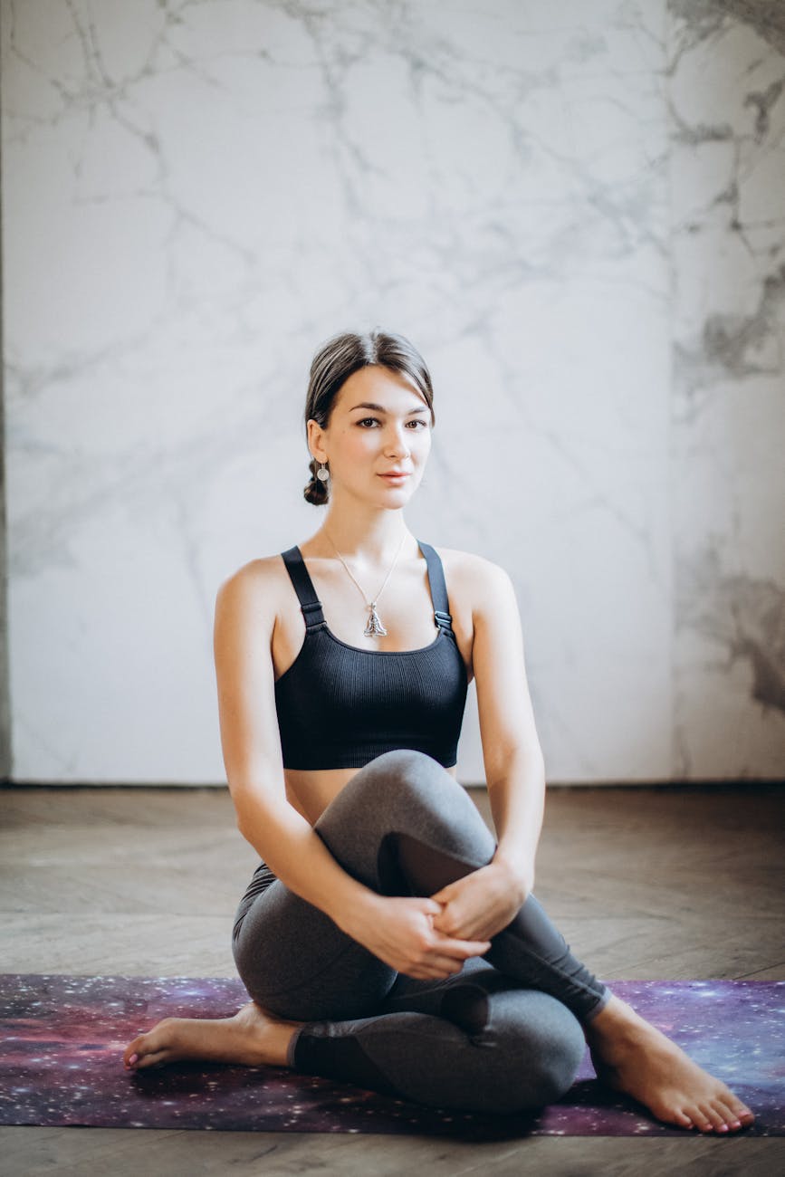 Person stretching gently on a yoga mat in a sunlit room.